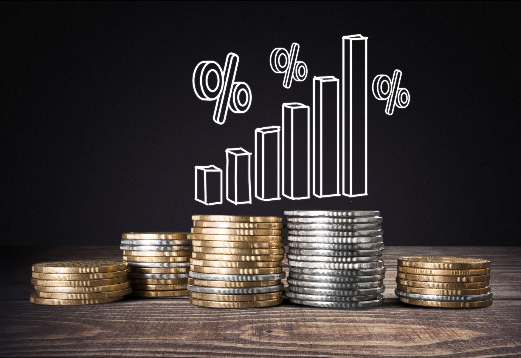 stacked coins under a graph with percentage signs 