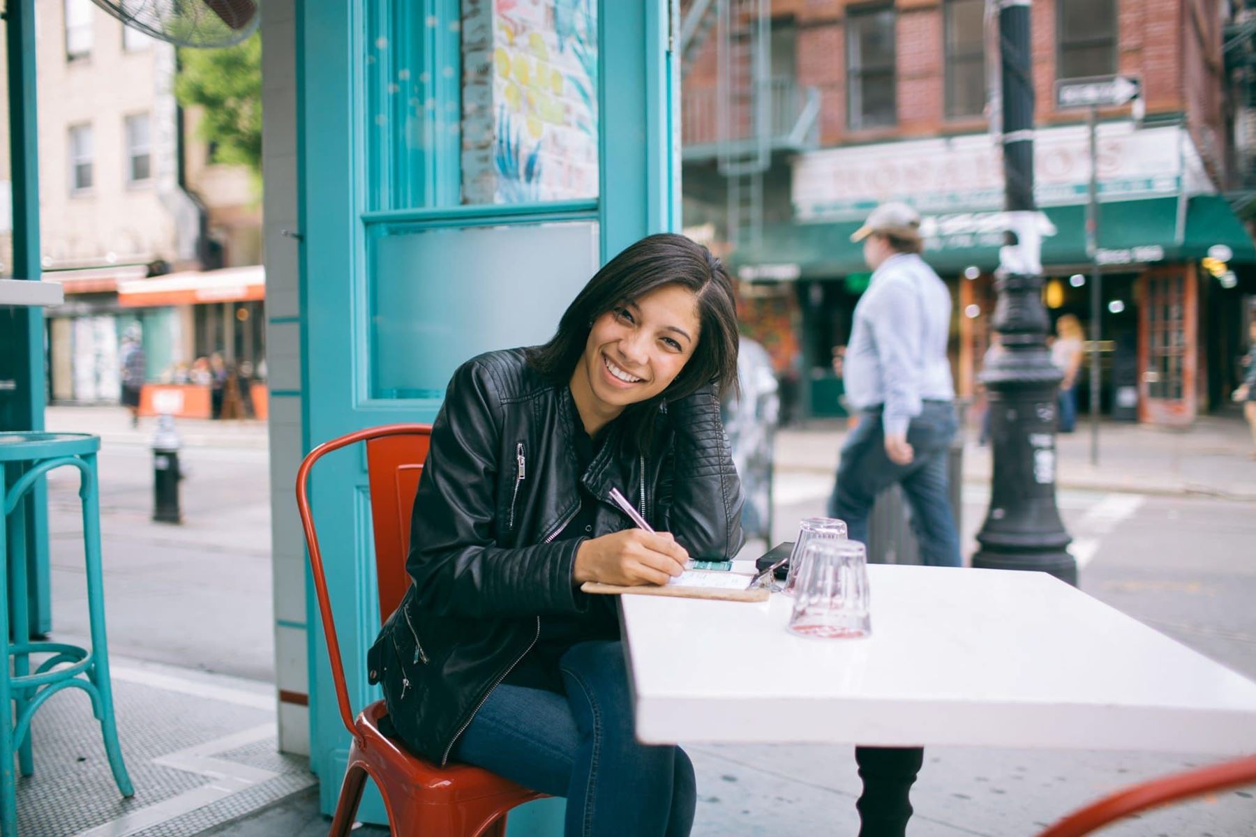 Woman writing on a pad sitting at a table